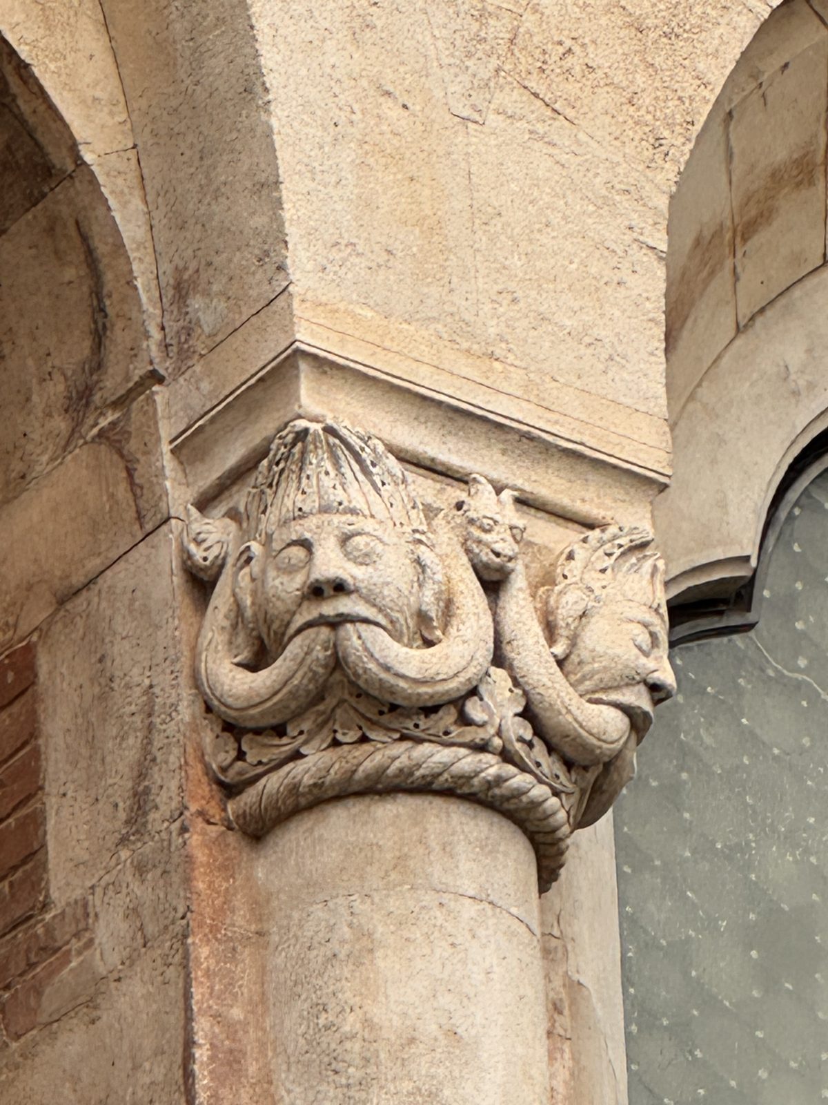 A mask from whose mouth serpents emerge, a frequent Romanesque image of corrupting speech and of the evil that comes out of a sinful heart