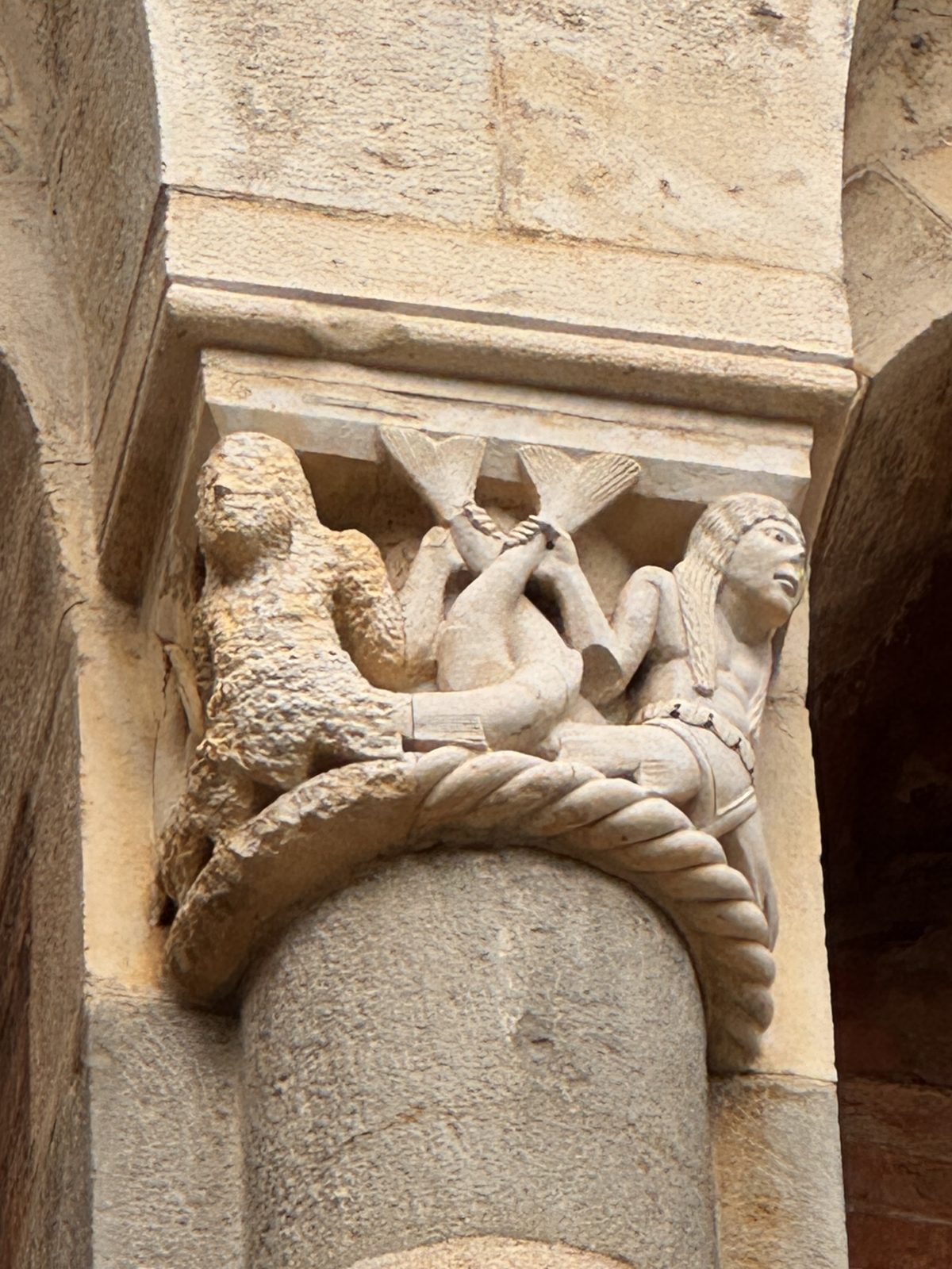 Two hybrid figures with crossed fishtails: sea creatures, half human, recalling the dangers of a world dominated by instinct