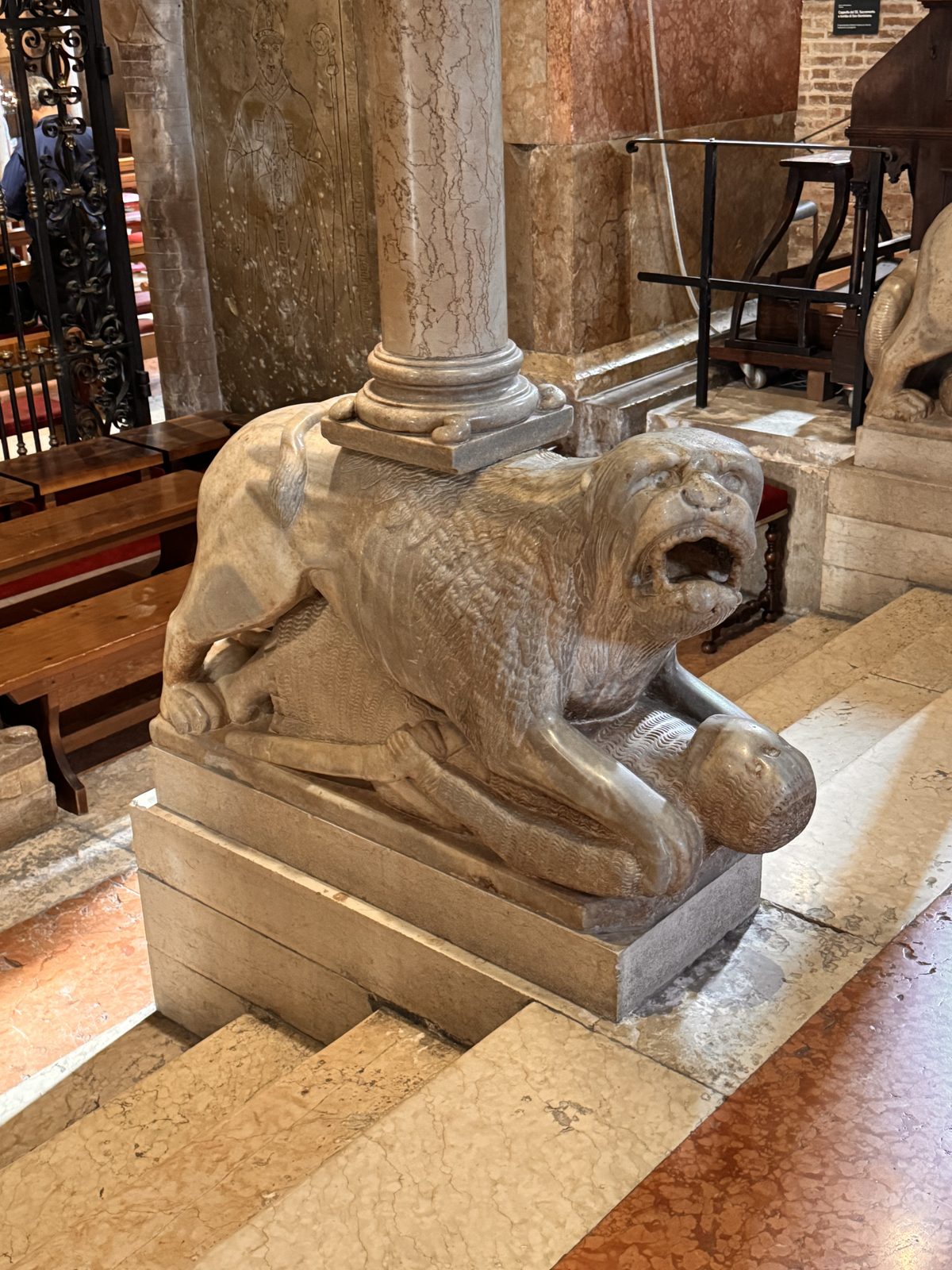 A lion grasping its prey at the base of a column of the pontile