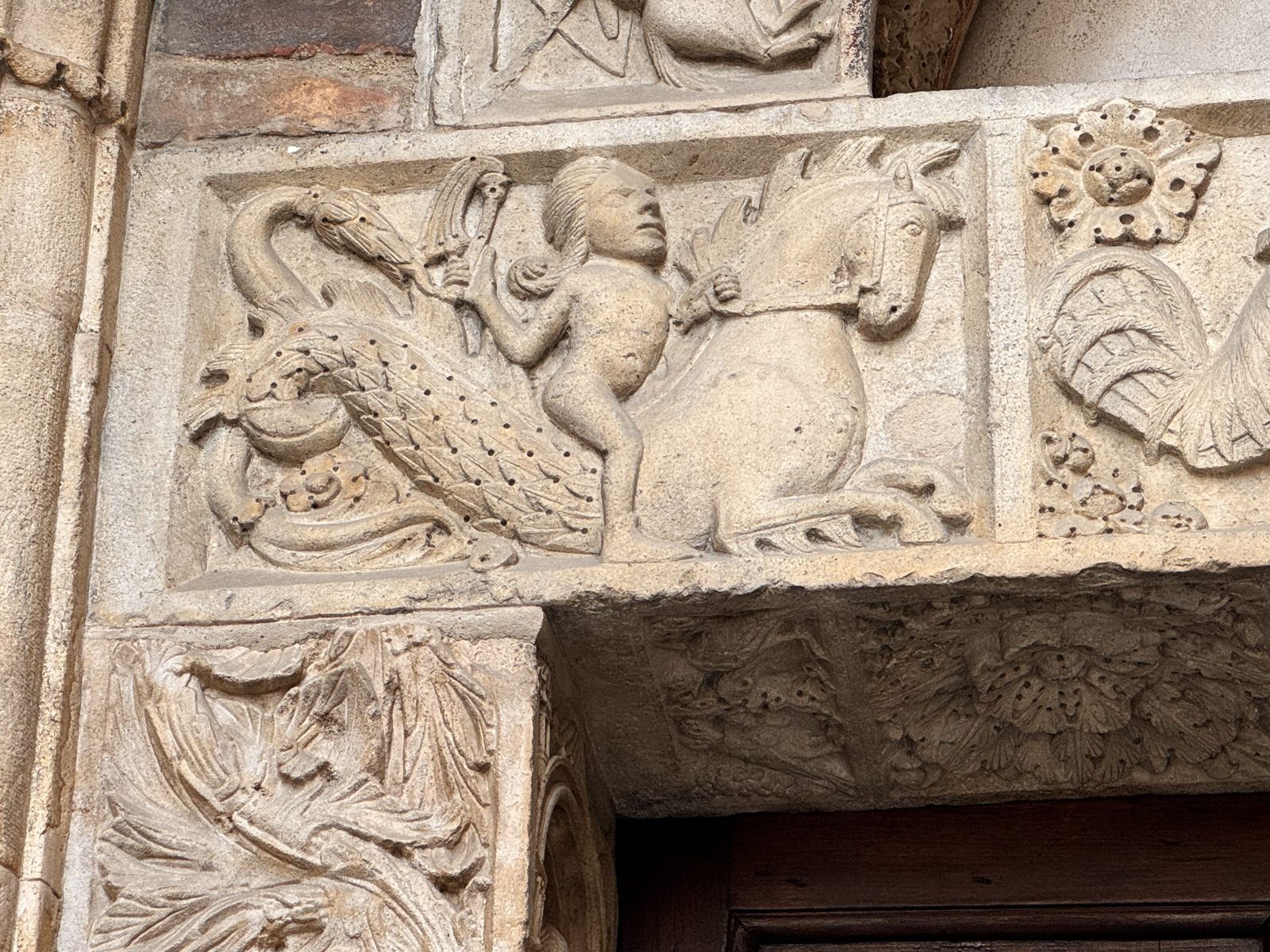 A naked child between a scaly, fish-tailed creature and a horse-like beast: one of the hybrid scenes of the lintel, whose exact meaning is still debated